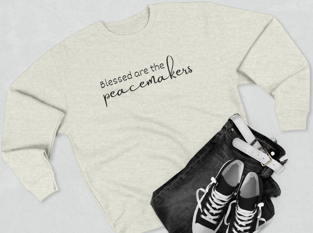 Blessed are the Peacemakers, Unisex Crewneck Christian Sweatshirt laying flat oatmeal